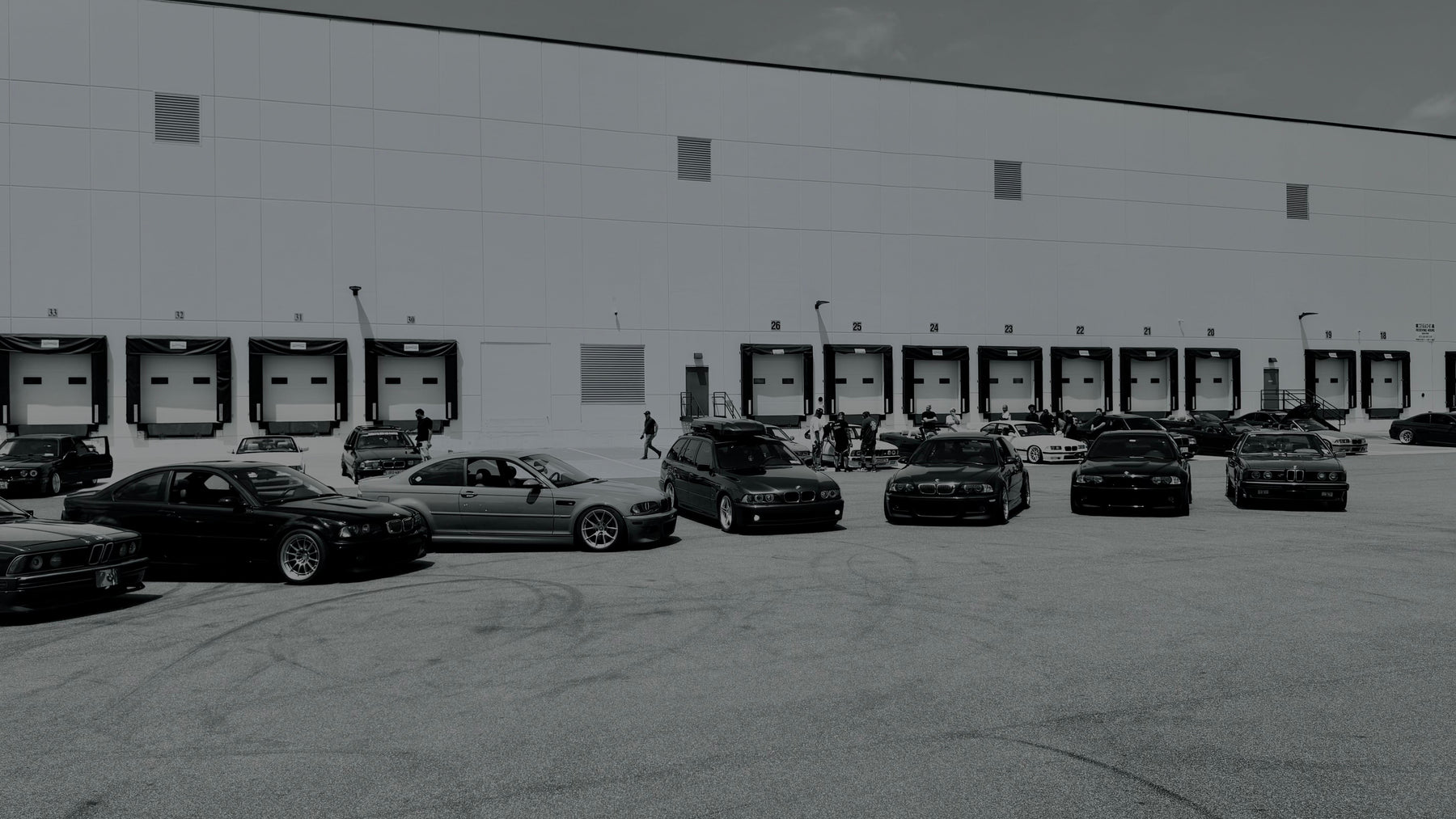 Wide view of BMWs and attendees at a car meet